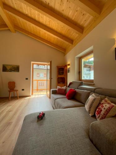 sala de estar con sofá y mesa en Casa Marta Dolomiti, en Vigo di Fassa