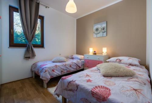 a bedroom with two twin beds and a window at Holiday house Mara with a private pool in Vodnjan