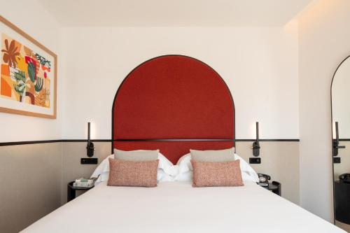 a bedroom with a large bed with a red headboard at The Editory Garden Porto Hotel in Porto