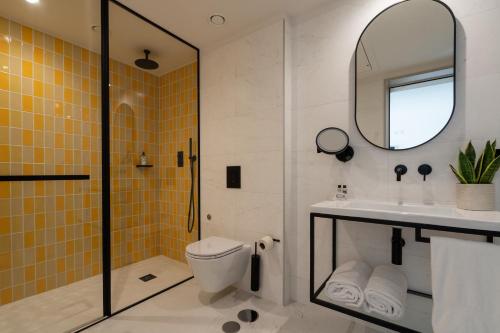 a bathroom with a toilet and a sink and a mirror at The Editory Garden Porto Hotel in Porto