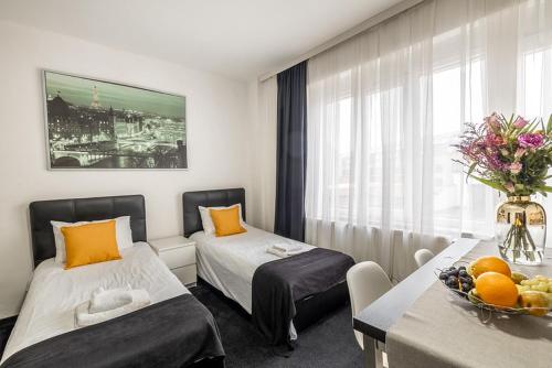una habitación de hotel con 2 camas y una mesa con un bol de fruta en Albert gare du Midi 31, en Bruselas