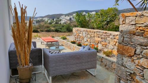 a patio with a couch and a stone wall at Scarpathia House in Katapola