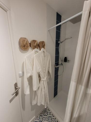 La salle de bains est pourvue de serviettes blanches suspendues à une cabine de douche. dans l'établissement La maison père camembert, à Honfleur