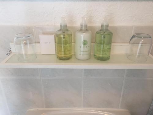three bottles of soap sitting on a shelf in a bathroom at Seaview Sanctuary in Eastbourne