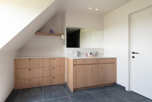 an attic bathroom with a sink and a sink at Country house - 'T Reigershof in Veurne