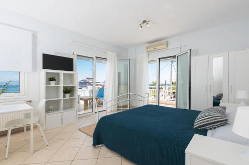 une chambre blanche avec un lit et un bureau dans l'établissement Urban Sea Side Apartments, à Thasos