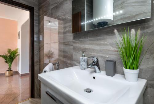 ein Badezimmer mit einem weißen Waschbecken und einem Spiegel in der Unterkunft Holiday house Mara with a private pool in Vodnjan