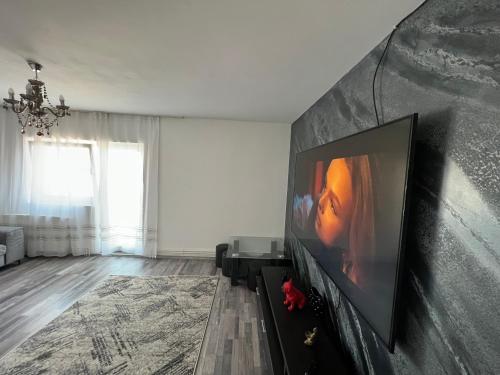 a living room with a flat screen tv on a wall at L&L Apartment in Braşov