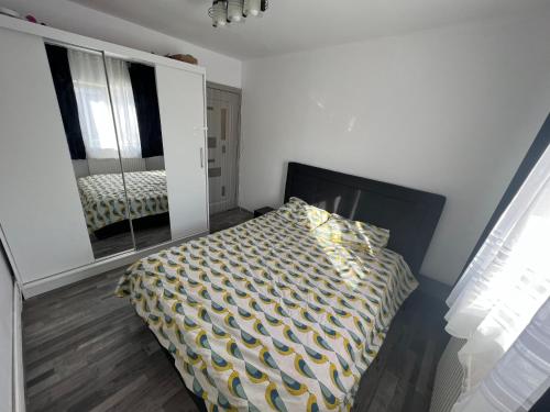 a bedroom with a bed and a mirror in it at L&L Apartment in Braşov