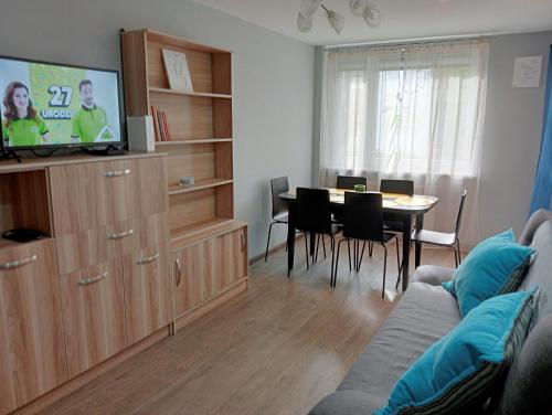 a living room with a couch and a dining room at Apartament Queen in Malbork