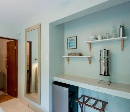uma cozinha com um balcão e um espelho em Casa Mia Guest House em Rincon