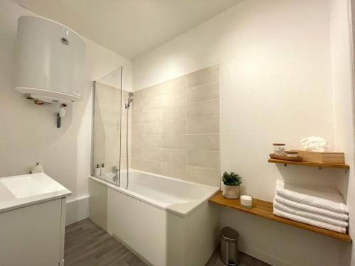 南蒂阿的住宿－Le Patio - Rénové et Proche lac，白色的浴室设有浴缸和水槽。