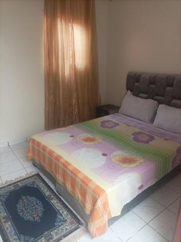 - une chambre avec un grand lit et une couverture dans l'établissement Riad Qariya siyahiya, à Marrakech