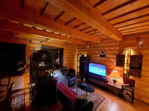 a living room with wooden walls and a television at Zrubík pod Znievom (Log Cabin Zniev) 