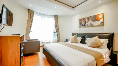 1 dormitorio con 1 cama grande y TV en Victory Villa Apartment Hotel, en Kigali