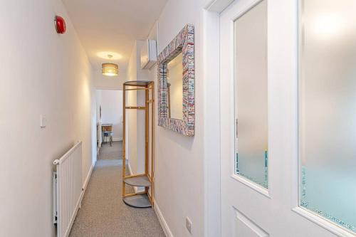 un couloir avec un miroir sur le mur et un escalier dans l'établissement Harestones - Bridge End Mill, à Settle