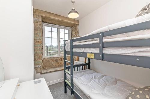 a room with two bunk beds and a window at Harestones - Bridge End Mill in Settle
