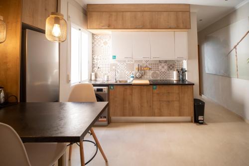 a kitchen with wooden cabinets and a table and chairs at Carthago Suites (Centro - Casco histórico) in Cartagena
