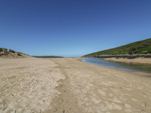 a view of a sandy beach next to the water at The Waves in Newquay