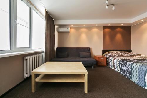 モスクワにあるCity Apartments Dinamoのベッド、ソファ、テーブルが備わるホテルルームです。
