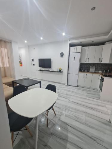 a living room with a table and chairs and a kitchen at Family House, CENTRO CIUDAD - 3 DORMITORIOS 6 1 0 3 1 0 8 3 1 in Ceuta