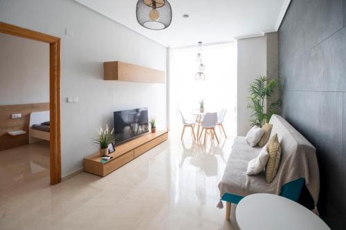 a living room with a couch and a television at Carthago Suites (Centro - Casco histórico) in Cartagena