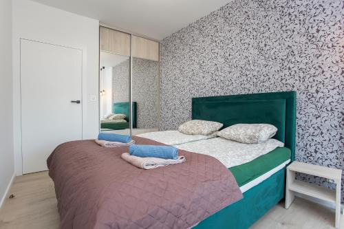 1 dormitorio con 1 cama con cabecero verde en Urban Jungle apartment Charlotte, en Białystok