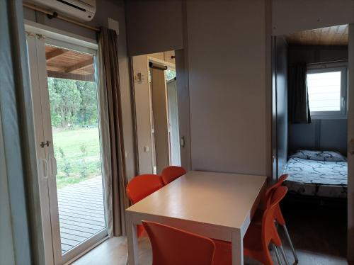 a room with a table and chairs and a bedroom at La Masia BG parc in Sant Pere Pescador