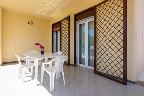 a dining room with a white table and chairs at Butterfly House in Trappeto