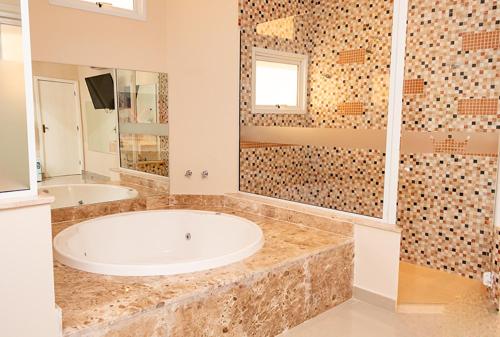 a large bathroom with a tub and a shower at Prime Motel Piracicaba in Piracicaba