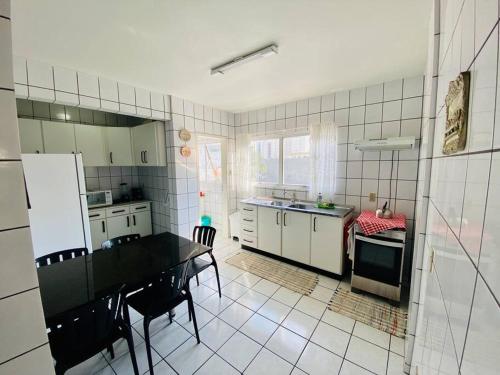 a kitchen with a table and chairs in a room at Ótima localização quadra mar e central in Balneário Camboriú