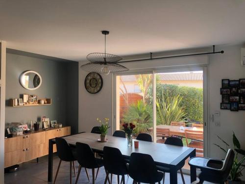 une salle à manger avec une table et des chaises et une fenêtre dans l'établissement Charmante maison climatisée avec piscine privée, à Montauroux