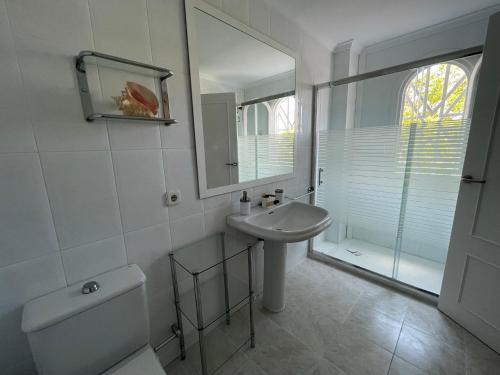 a white bathroom with a sink and a mirror at Casa Olé in Jávea