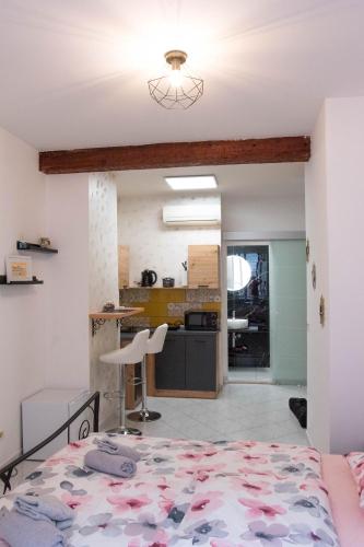 a bedroom with a bed and a kitchen at Apartmani DA in Piran