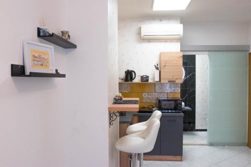 a kitchen with a white chair and a counter at Apartmani DA in Piran
