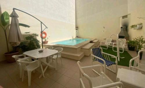 une terrasse avec une table et des chaises ainsi qu'une piscine dans l'établissement The Valley Maisonette with private pool in M'scala, à Marsaskala