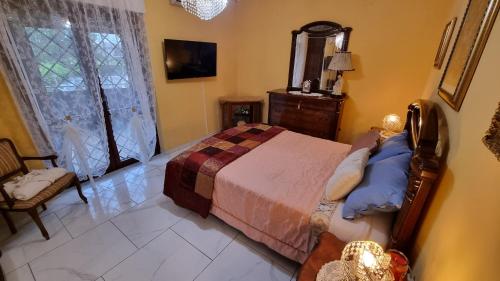 1 dormitorio con 1 cama, 1 silla y 1 ventana en Casina Della Nonna appartamento esclusivo con Parcheggio e Terrazza, en Lariano