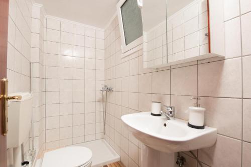 une salle de bain blanche avec un lavabo et des toilettes dans l'établissement Urban Sea Side Apartments, à Thasos