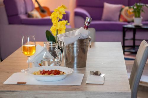 a table with a bowl of food and a glass of wine at Butterfly House in Trappeto