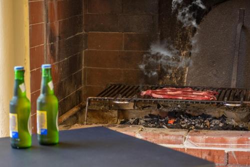 two bottles of beer sitting next to a brick oven at Butterfly House in Trappeto