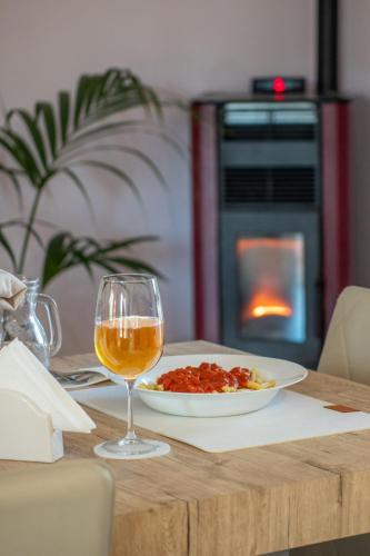 a table with a plate of food and a glass of wine at Butterfly House in Trappeto