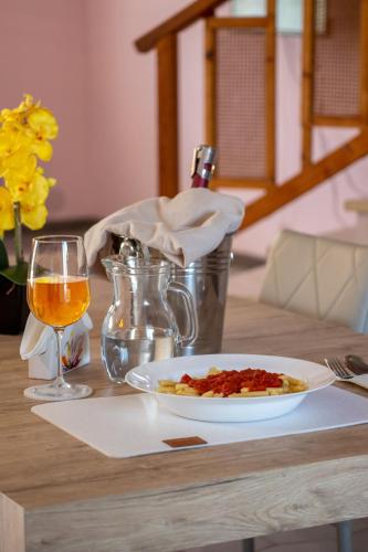 a table with a plate of food and a glass of wine at Butterfly House in Trappeto