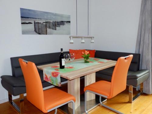 a dining room with a table with orange chairs at Ferienhaus Bella Vista in Presseggersee