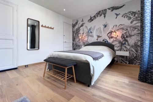 a bedroom with a bed and a wall with flowers at Appart 2 personnes à 50m des commerces & mer in Barneville-Carteret