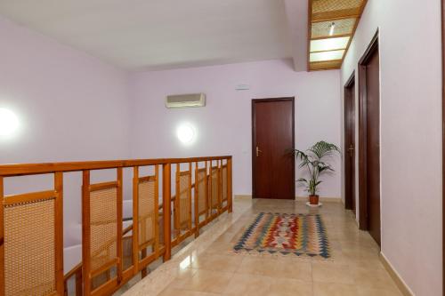 a hallway with a wooden railing and a plant on the floor at Butterfly House in Trappeto