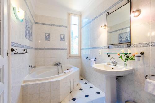 a white bathroom with a sink and a tub and a sink at ROC FLEURY - Cap d'Ail, VI1094 by Riviera Holiday Homes in Cap d'Ail