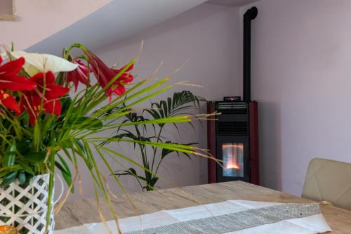 a room with a table with flowers and a fireplace at Butterfly House in Trappeto