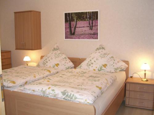 a bedroom with two beds and a painting on the wall at Ferienwohnung Am Hasenberg in Hermannsburg