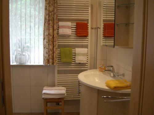 a bathroom with a sink and a window with towels at Ferienwohnung Am Hasenberg in Hermannsburg