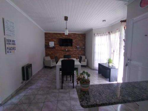ein Wohnzimmer mit einem Tisch und einem Esszimmer in der Unterkunft Alojamiento Turístico Los Pinos in Villa Elisa